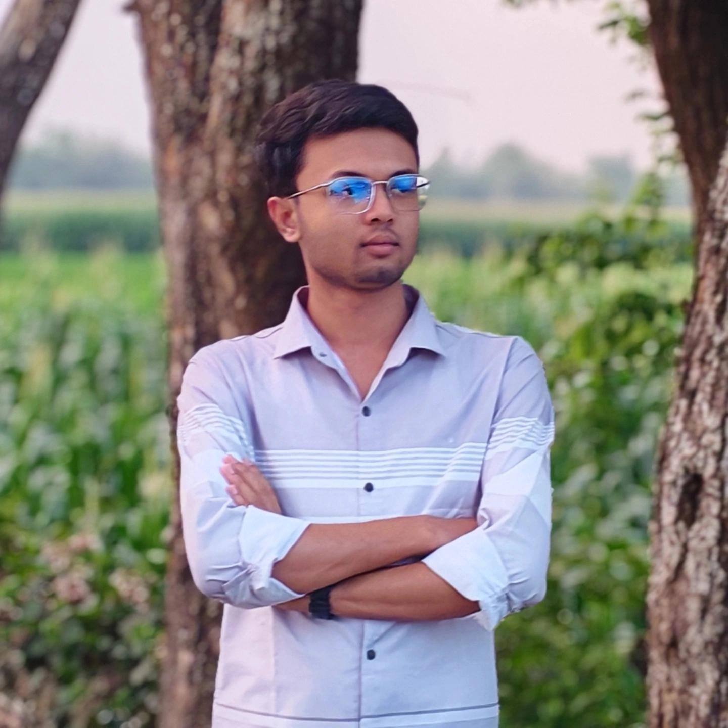 Faysal standing outdoors near a corn field