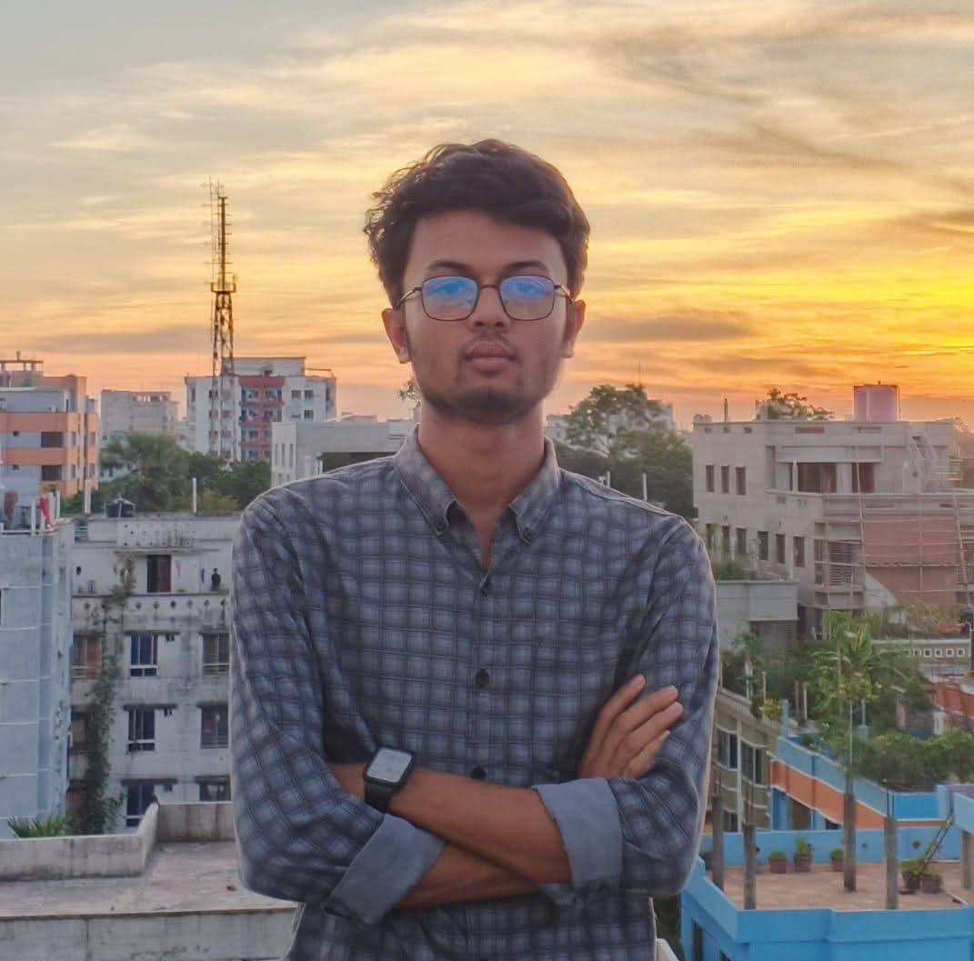 Faysal on a rooftop at sunset with the city skyline behind him